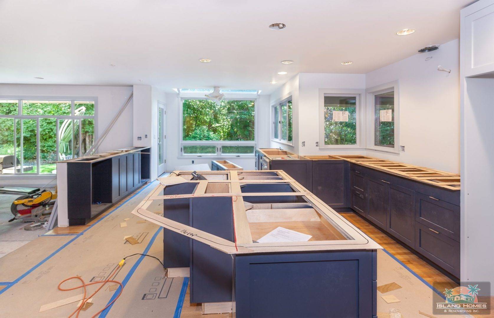 A modern kitchen featuring blue cabinets and warm wood floors, creating a stylish and inviting atmosphere.
