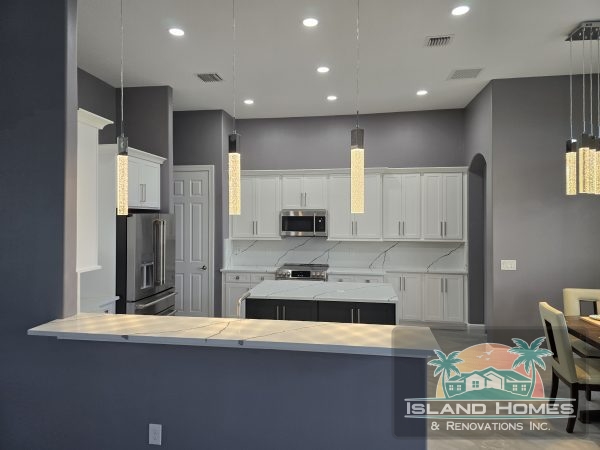 A modern kitchen featuring gray walls and sleek white cabinets, creating a stylish and contemporary atmosphere.