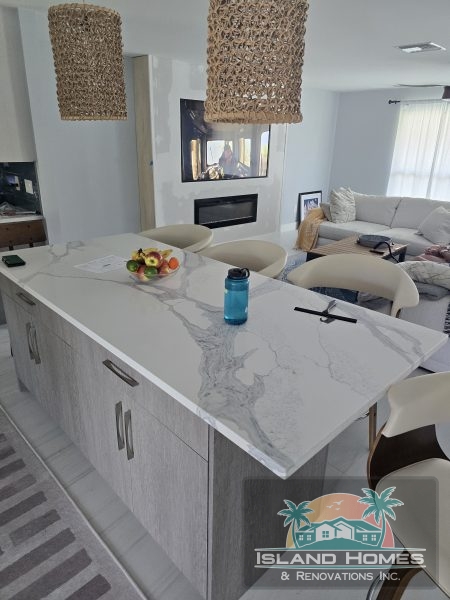 A modern kitchen featuring elegant white marble countertops and matching cabinets.