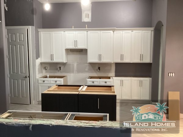 A well-designed kitchen with gray walls and white cabinets, showcasing a clean and elegant aesthetic.