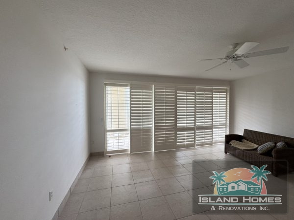 A clean, empty kitchen and living room showcasing modern design and spaciousness.
