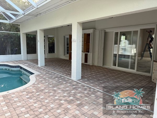 A serene home pool surrounded by a covered patio, offering a relaxing outdoor space for leisure and enjoyment.