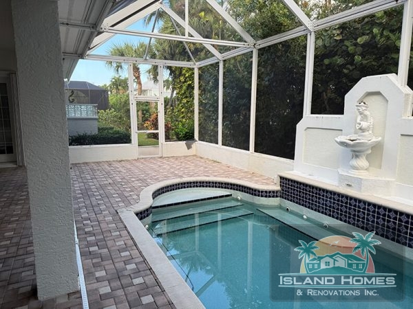 A serene home pool surrounded by a covered patio, offering a relaxing outdoor space for leisure and enjoyment.