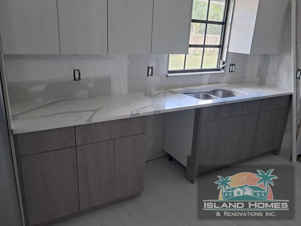A well-designed kitchen with gray walls and white cabinets, showcasing a clean and elegant aesthetic.