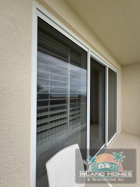 A patio featuring sliding glass doors and a single chair, inviting relaxation in an outdoor setting.